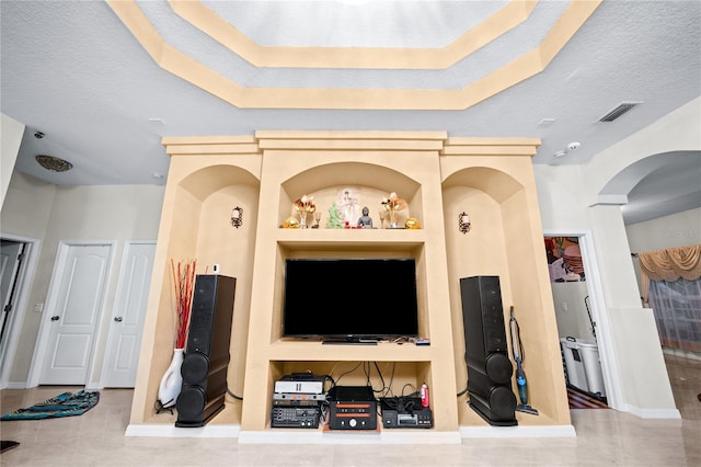 living room with tile patterned floors, a textured ceiling, and built in shelves