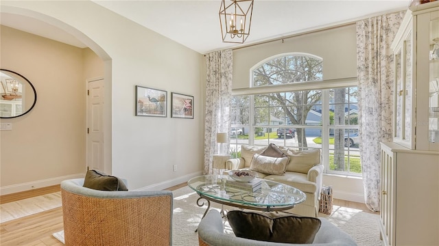 living area with light hardwood / wood-style floors, a chandelier, and plenty of natural light