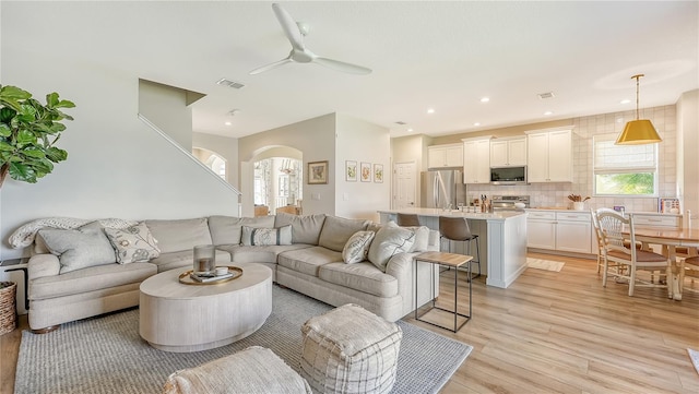 living room featuring light hardwood / wood-style flooring and ceiling fan