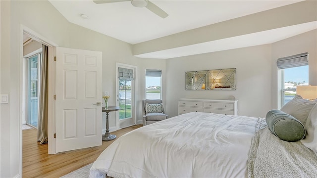 bedroom featuring light hardwood / wood-style floors, multiple windows, access to exterior, and ceiling fan