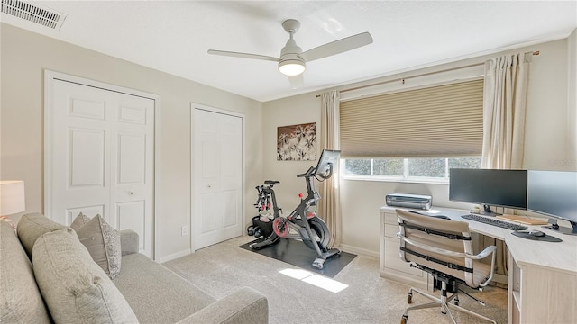 carpeted office space featuring ceiling fan