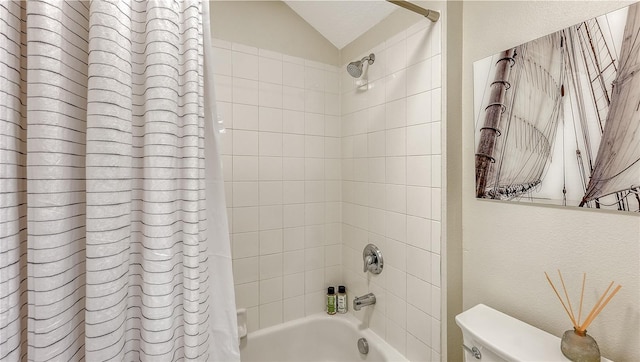 bathroom with toilet, vaulted ceiling, and shower / tub combo