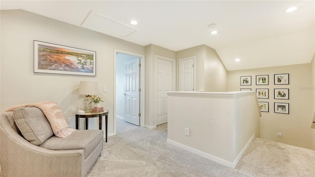 sitting room with lofted ceiling and light carpet