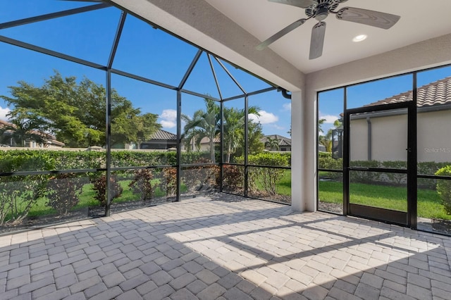 unfurnished sunroom featuring ceiling fan