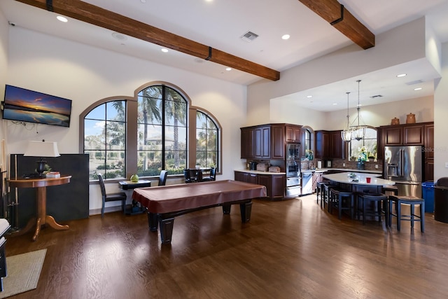 interior space with dark wood-type flooring, beam ceiling, an inviting chandelier, a high ceiling, and pool table