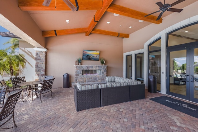 view of patio / terrace featuring an outdoor living space with a fireplace, ceiling fan, and french doors