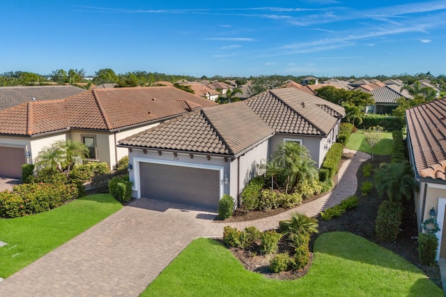 mediterranean / spanish home featuring a front lawn and a garage