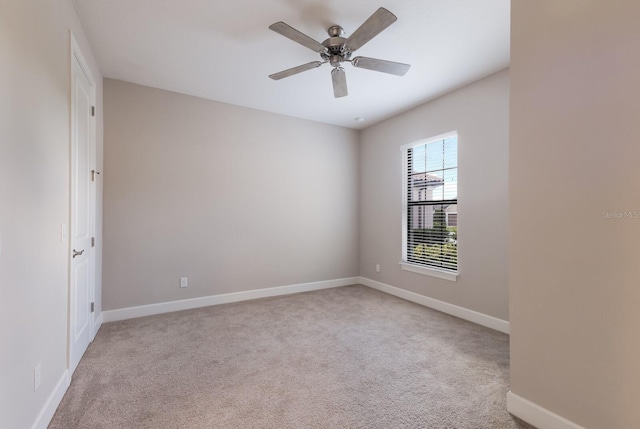 empty room featuring ceiling fan and light colored carpet