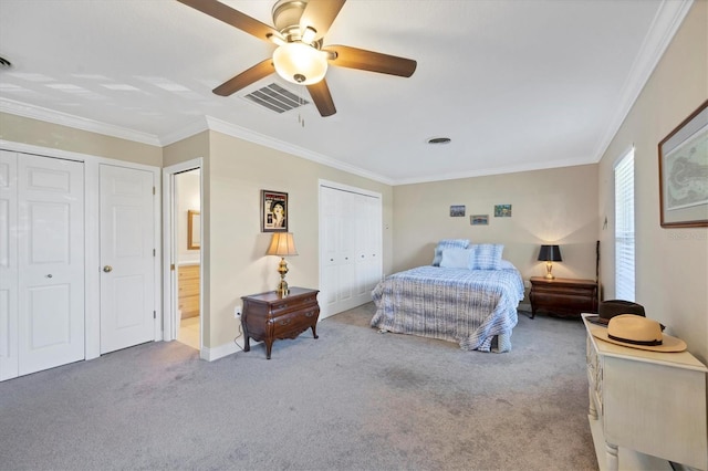 carpeted bedroom with ornamental molding, two closets, and ceiling fan