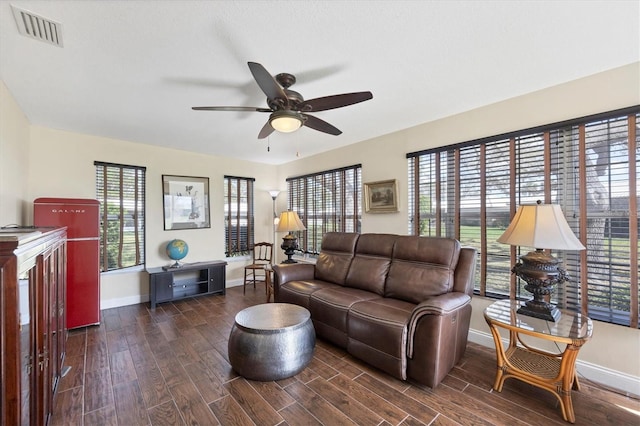 living room featuring ceiling fan, dark hardwood / wood-style flooring, and a wealth of natural light