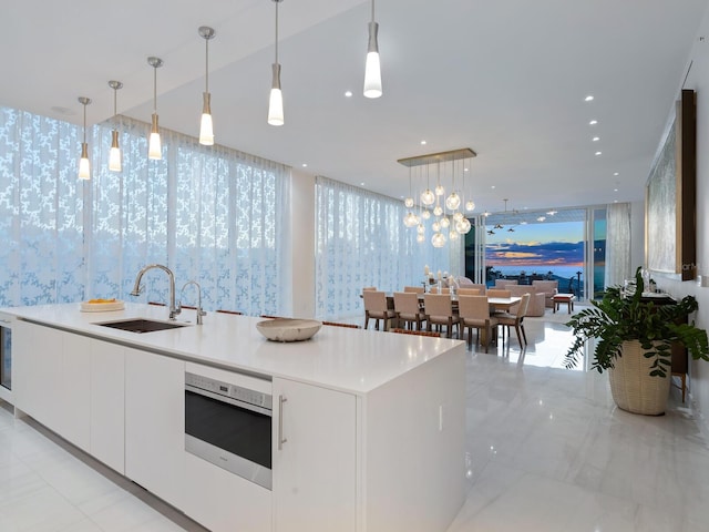 4651 Gulf Of Mexico Dr Unit 402, Longboat Key, FL 34228 - kitchen with a sink, white cabinets, open floor plan, built in microwave, and modern cabinets