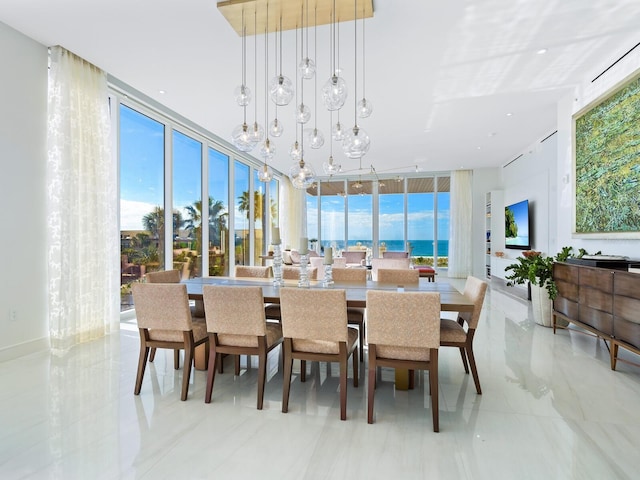 dining area with an inviting chandelier, light tile patterned flooring, and a wall of windows