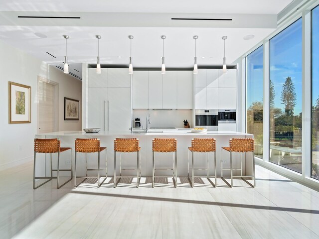 4651 Gulf Of Mexico Dr Unit 402, Longboat Key, FL 34228 - kitchen with modern cabinets, a kitchen breakfast bar, white cabinetry, oven, and decorative light fixtures