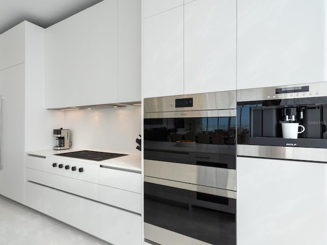 kitchen with stainless steel double oven and white cabinets