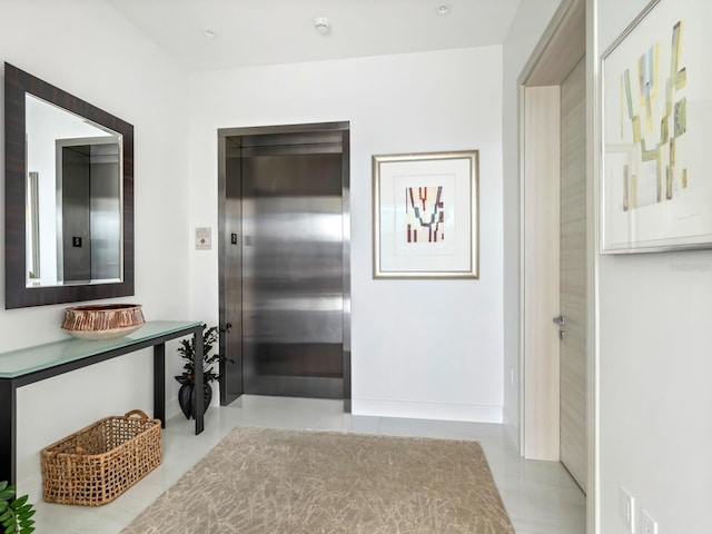 hall featuring elevator and light tile patterned floors