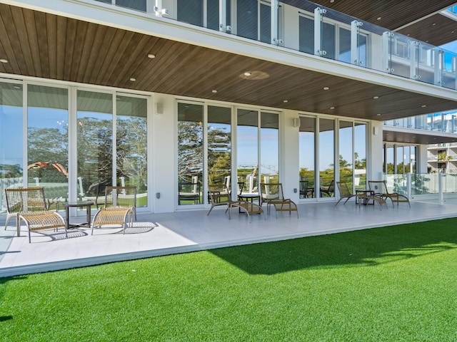 back of property with a patio area and a yard