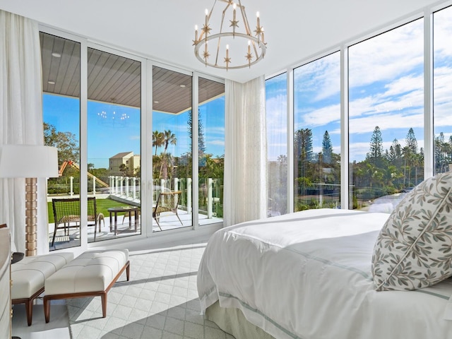 bedroom featuring floor to ceiling windows and an inviting chandelier