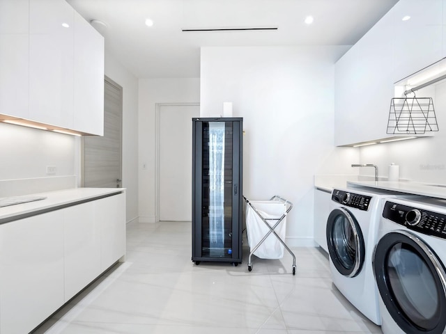 4651 Gulf Of Mexico Dr Unit 402, Longboat Key, FL 34228 - laundry room with washer and clothes dryer, baseboards, beverage cooler, cabinet space, and light tile patterned floors