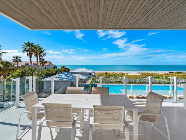 balcony featuring a view of the beach and a water view