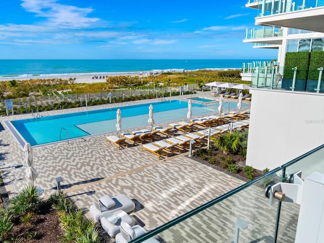 view of pool with a view of the beach and a water view