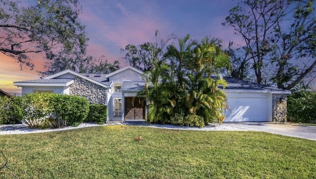 view of property hidden behind natural elements with a yard and a garage