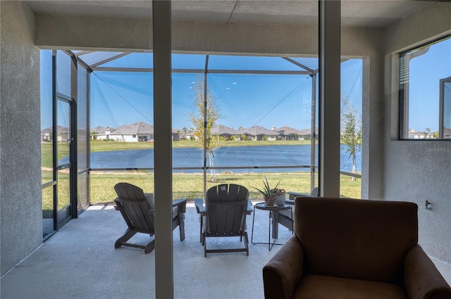 sunroom featuring a water view