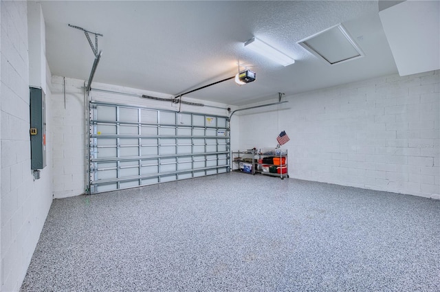 garage with concrete block wall, electric panel, and a garage door opener