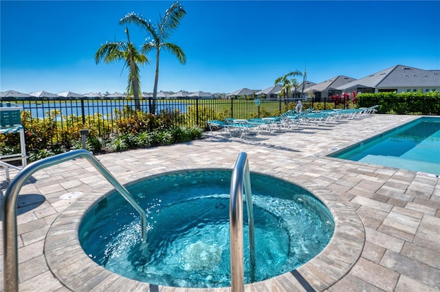 community pool with a patio area, a residential view, fence, and a community hot tub