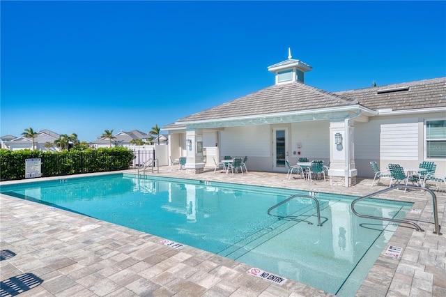 community pool with fence and a patio