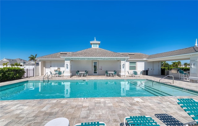 community pool featuring fence and a patio