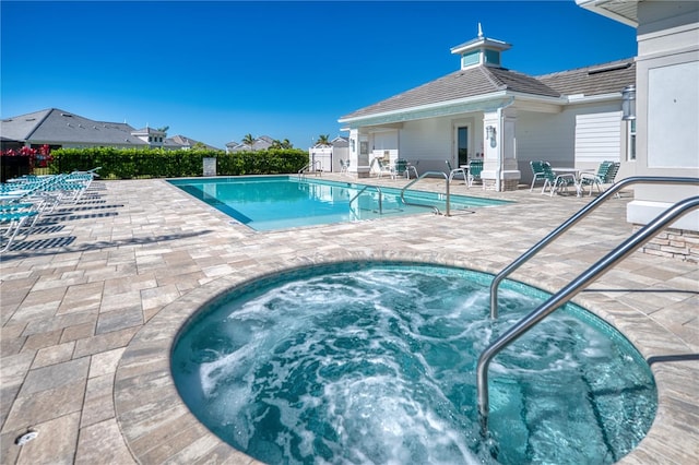 pool featuring a hot tub and a patio