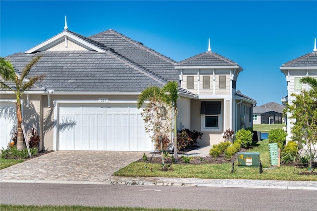 view of front of property with a garage, decorative driveway, and stucco siding