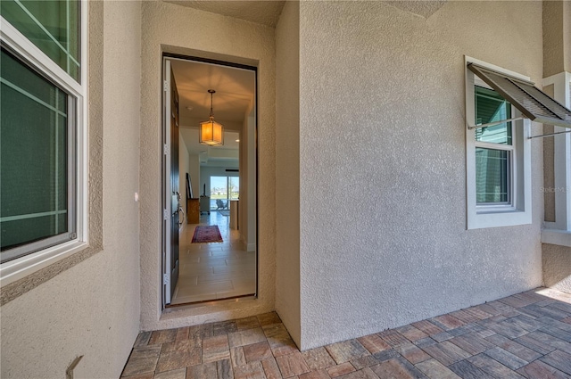 entrance to property featuring stucco siding