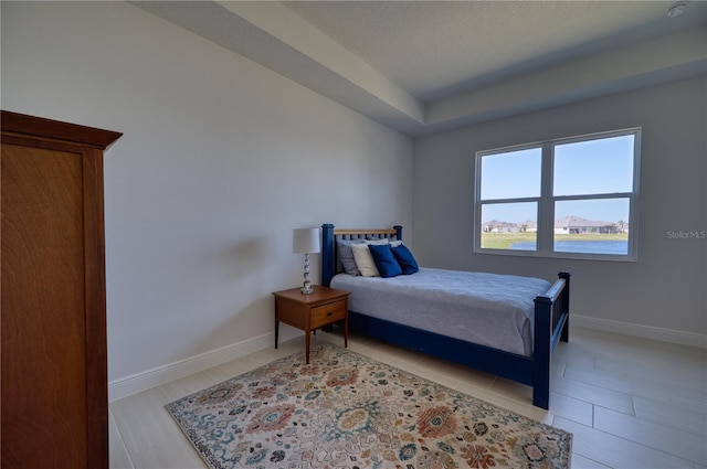 bedroom featuring light tile patterned floors and baseboards