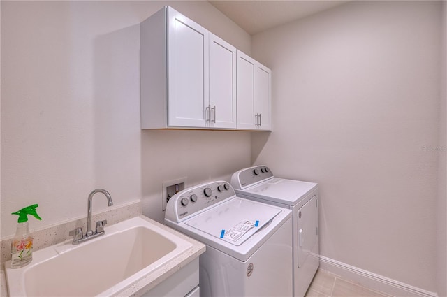 laundry room with baseboards, a sink, cabinet space, and washer and dryer