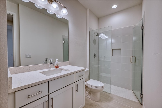 bathroom with tile patterned flooring, a shower stall, vanity, and toilet