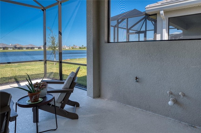 sunroom featuring a water view