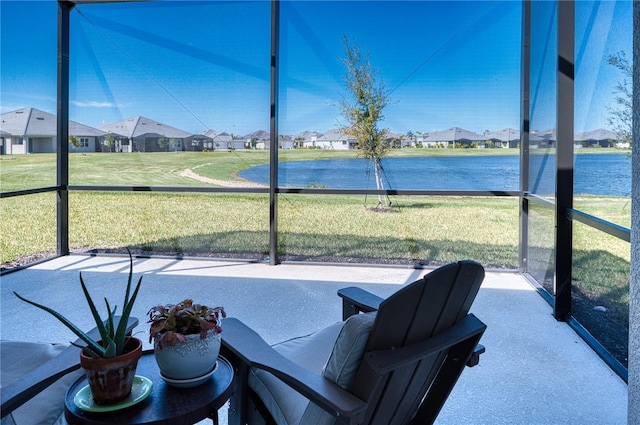 unfurnished sunroom featuring a residential view and a water view