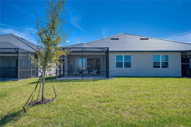 rear view of property with a yard, a patio area, a lanai, and stucco siding