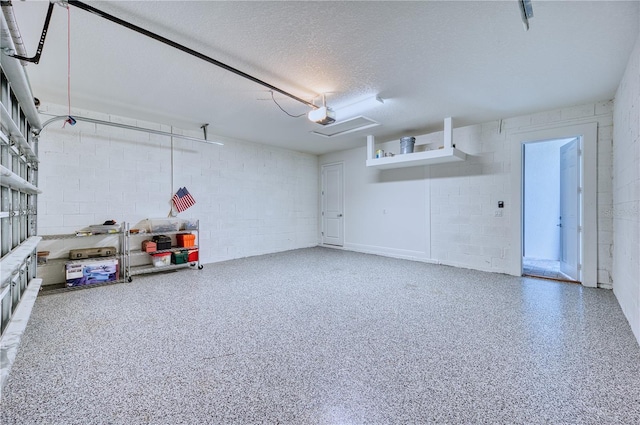 garage with concrete block wall and a garage door opener