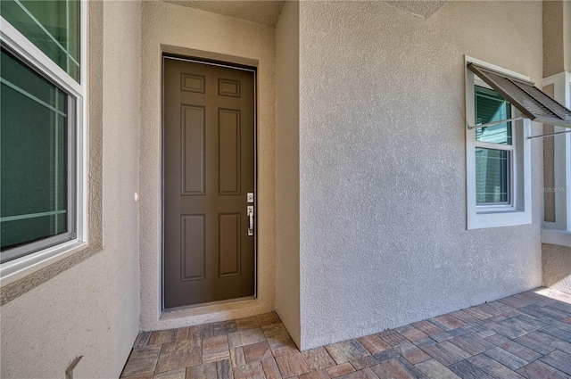 entrance to property featuring stucco siding