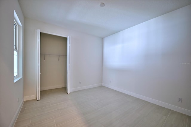 unfurnished bedroom featuring a closet, light wood finished floors, and baseboards