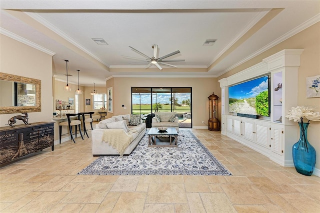 living room featuring ornamental molding, a tray ceiling, and ceiling fan