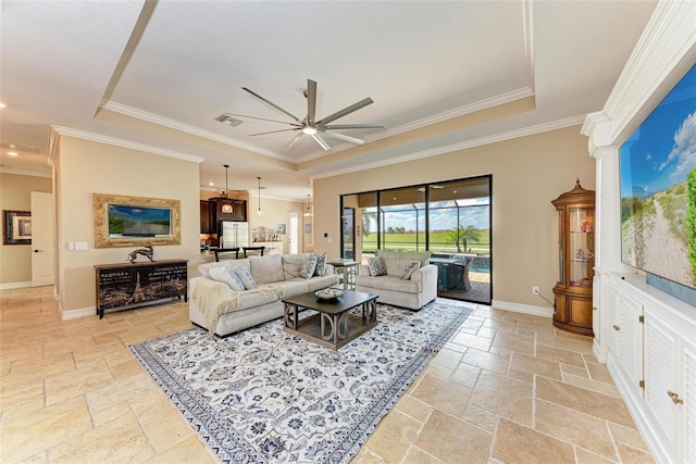 living room with crown molding, a tray ceiling, and ceiling fan