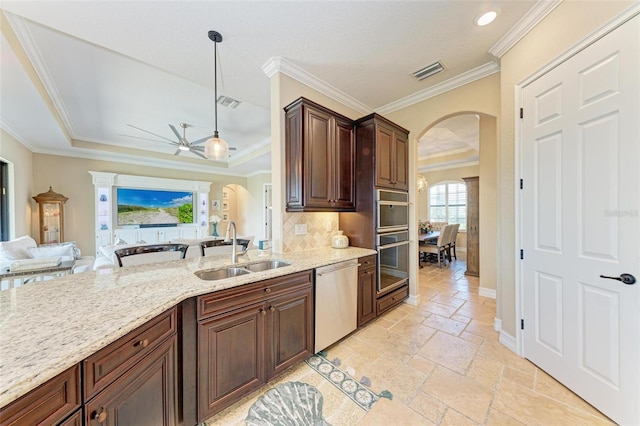 kitchen with sink, ceiling fan, pendant lighting, stainless steel dishwasher, and ornamental molding