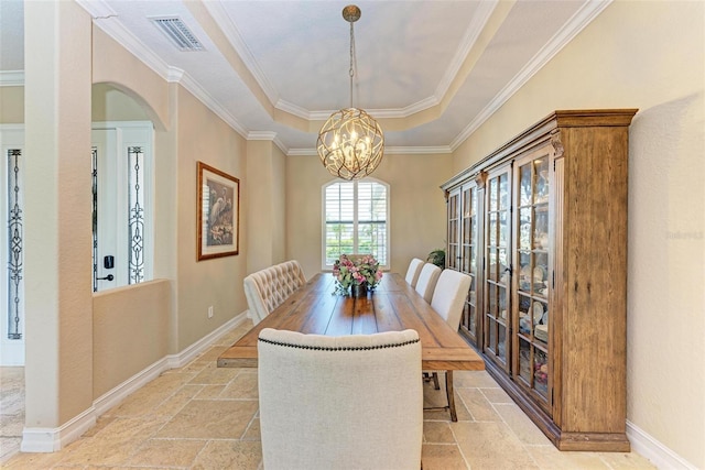 dining space with ornamental molding, a chandelier, and a tray ceiling