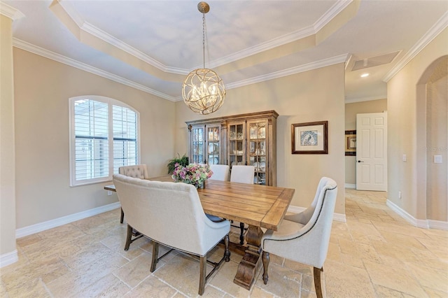 dining area with a notable chandelier, ornamental molding, and a tray ceiling