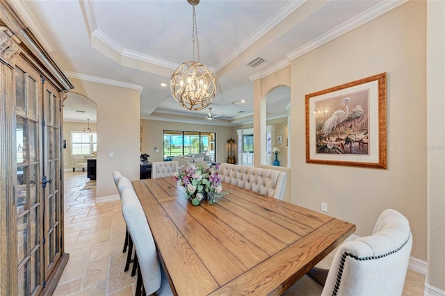 dining space featuring crown molding, a tray ceiling, and ceiling fan