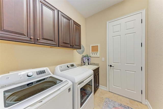 laundry area featuring sink, washing machine and dryer, and cabinets