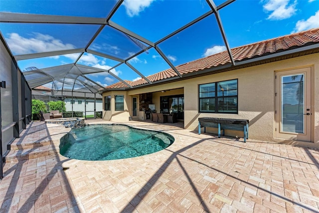 view of pool with a patio area, an in ground hot tub, and glass enclosure